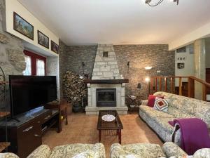 a living room with a fireplace and a couch at Casa dos Cabencos in Terras de Bouro