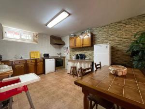 a kitchen with a wooden table and a kitchen with white appliances at Casa dos Cabencos in Terras de Bouro