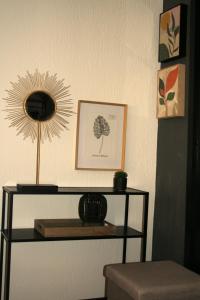 a shelf with a mirror on a wall with a table at Appartement ELYNE Quartier des Templiers à 400m de la mer in Saint-Raphaël