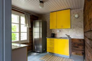 a kitchen with yellow cabinets and a stainless steel refrigerator at Myllytupa in Merikaarto