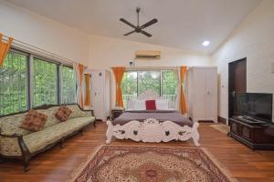 罗纳瓦拉Heritage Bliss By Mulberry Stays的一间带床、沙发和电视的卧室