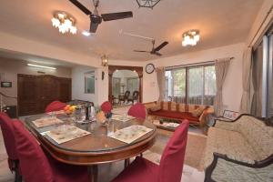 罗纳瓦拉Heritage Bliss By Mulberry Stays的客厅配有桌子和红色椅子