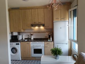 a kitchen with wooden cabinets and a white refrigerator at Casa Ferino in Villaviciosa