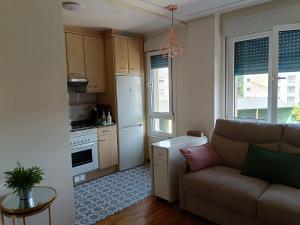 a living room with a couch and a kitchen at Casa Ferino in Villaviciosa