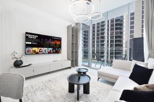 a living room with a tv on a wall at Exclusive 1BR District 1 - Crystal Lagoon Access in Dubai