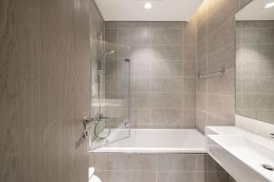 a bathroom with a shower and a tub and a sink at Exclusive 1BR District 1 - Crystal Lagoon Access in Dubai +28 photos