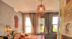 a living room with a bed and windows and a chandelier at Velespit Hotel in Antalya