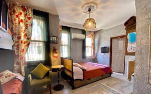 a bedroom with a bed and a chair and windows at Velespit Hotel in Antalya