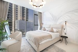 a bedroom with a bed and a chair and a window at Exclusive 1BR District 1 - Crystal Lagoon Access in Dubai