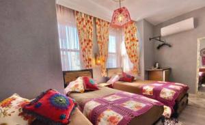 a bedroom with two beds and a couch and windows at Velespit Hotel in Antalya