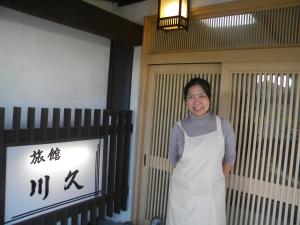 指宿市にあるFamily Ryokan Kawakyu with Showa Retro, private hot springの女がドアの前に立っている