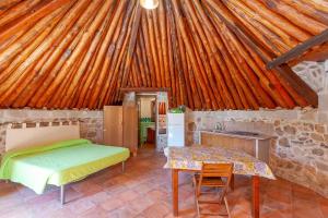 a bedroom with a bed and a table in a room at B&B Pettirosso Garden in San Teodoro