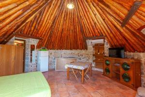 a kitchen with a wooden roof with a bed and a table at B&B Pettirosso Garden in San Teodoro