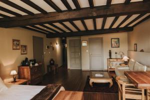 a living room with a bed and a table at LOGIS HÔTEL-RESTAURANT - Le Moulin d'Artres in Artres