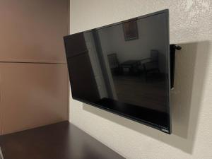 a flat screen tv hanging on a wall at Sequoia Motel in Fresno