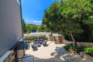 un patio con un sofá y un árbol en VILLA ERIKA, en Crikvenica