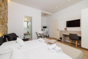 Un dormitorio con dos camas y un escritorio y un televisor. en VILLA ERIKA, en Crikvenica