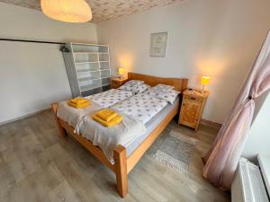a bedroom with a large bed with yellow towels on it at Apartmán U Jiroutů in Rokytnice v Orlických Horách