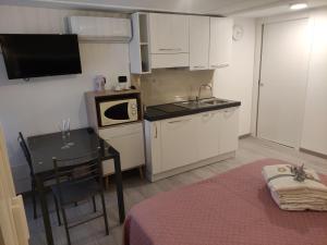 a small kitchen with a table and a sink and a microwave at Palazzo Carignano in Chioggia +9 photos