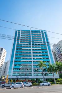 a large blue building with cars parked in front of it at BSB STAY Flats particulares - Athos SHN in Brasília