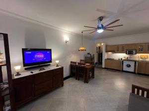 a living room with a flat screen tv and a kitchen at Cim and Sands in Goa