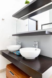 two sinks on a black counter in a bathroom at 3BR Downtown Condo with Amazing Views in Cabo San Lucas