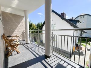 a balcony with a chair and a railing at Chatka Morska in Karwia