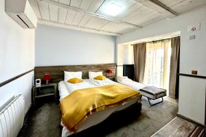 a bedroom with a bed with a yellow blanket on it at MARADA felix in Hidişelul-de Sus +94 photos