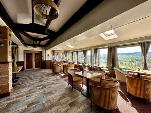 a restaurant with tables and chairs and large windows at MARADA felix in Hidişelul-de Sus