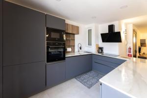 a kitchen with black cabinets and a stove top oven at Luxury Family Apartment close to Mgarr ix-Xini with Parking in Xewkija