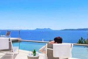 シヴォタにあるVILLA ODISSOS - Private Paradise with 2 infinity pools & Sea accessのスイミングプール横の椅子に座る男 +36枚の写真