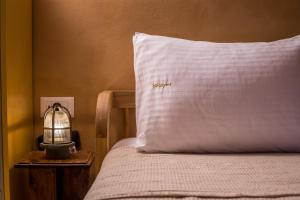 a bed with a pillow with the word spanish on it at kalosymi studio, Symi in Symi