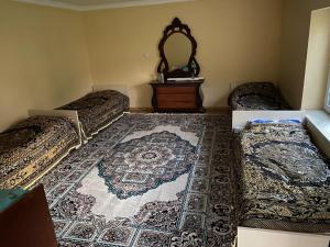 a room with two beds and a rug on the floor at Restaurant & Hotel in Qonaqkǝnd +3 photos