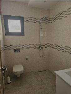 a bathroom with a shower with a toilet and a sink at Villa récente Climatisée Kelibia 8min de la plage in Kelibia +19 photos
