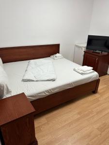 a bedroom with a bed and a tv on a table at Pensiunea Balea in Cîmpeni