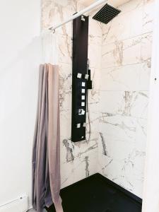 a shower with a black and white marble wall at À Bon Port in Perce +18 photos