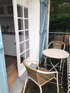a patio with a table and chairs on a porch at La Gimoniere in La Barre-de-Monts