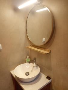 a bathroom with a sink and a large mirror at Ενοικιαζόμενα Δωμάτια "ΜΕΡΣΙΝΗ" in Karistos