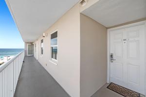 a hallway with a white door and the ocean at Tradewinds 307 in Orange Beach
