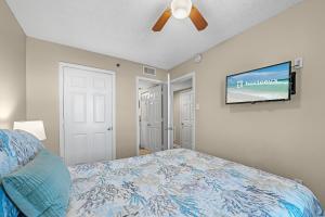 a bedroom with a bed and a flat screen tv at Tradewinds 307 in Orange Beach