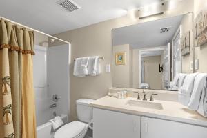 a bathroom with a sink and a toilet and a mirror at Tradewinds 307 in Orange Beach +27 photos