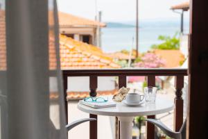 a small table with a cup on a balcony at Athos Guest House Pansion in Ouranoupoli