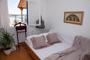 ポルト・ヘリにあるAroura Homes 3BR 2BA Porto Heliのベッド1台(枕付)、窓が備わる客室です。