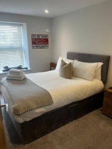 a bed in a bedroom with a sign on the wall at Modern Ground Floor Apartment in Midsomer Norton