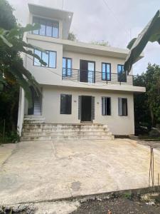 a large white house with stairs in front of it at HaCaSeMa Transient House in Acala