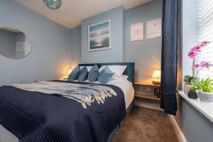 a bedroom with a bed with blue walls at The Tides, 3 bed house Morecambe in Morecambe