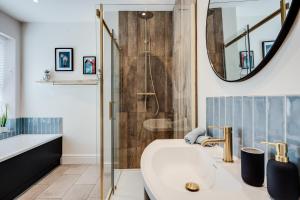 a bathroom with a shower and a tub and a sink at The Tides, 3 bed house Morecambe in Morecambe +28 photos