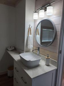 a bathroom with a bowl sink and a mirror at South Beach Bungalow in Point Roberts