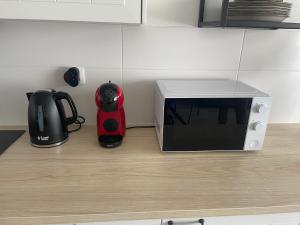 a microwave sitting on a kitchen counter next to a coffee maker at Studio Casa Brisa Del Mar in Middelkerke