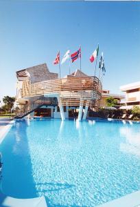 ein Gebäude mit Flaggen auf einem Wasserpool in der Unterkunft Hotel Poseidon in Terracina